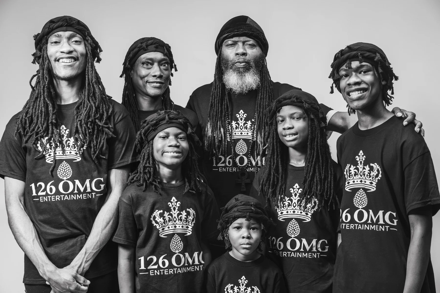 Black-and-white group portrait of the 126 OMG Entertainment family